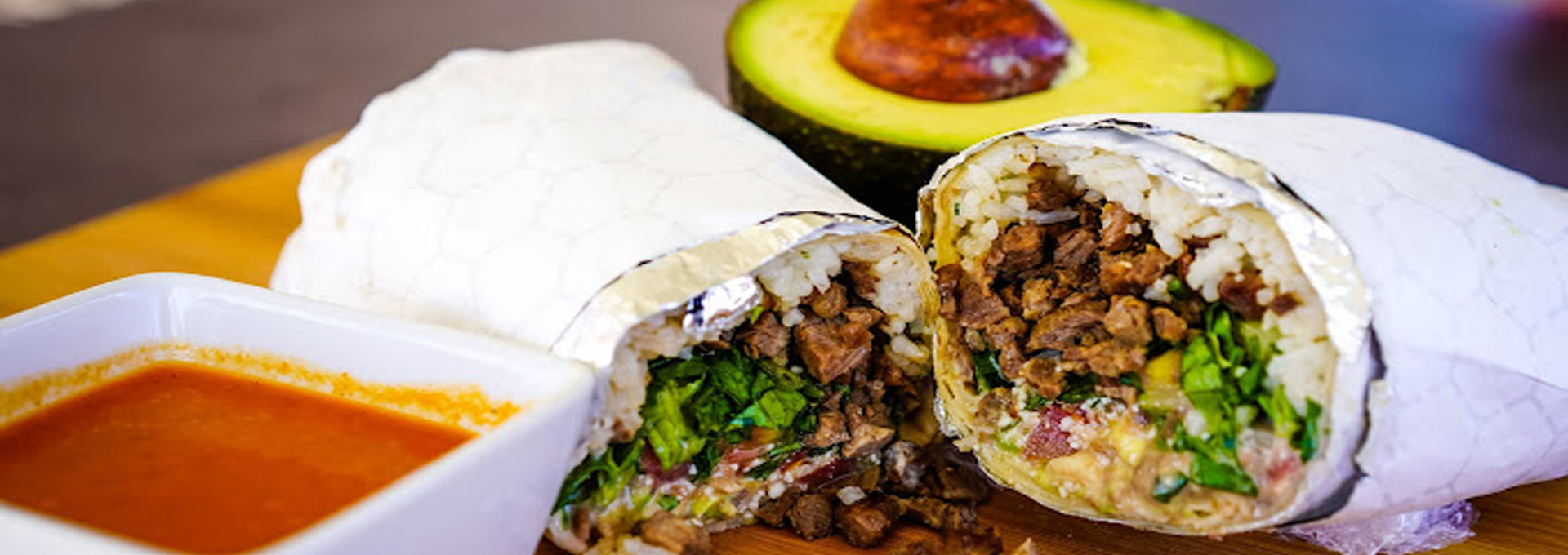 Burrito cut in half with beef, rice, and salsa